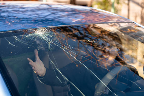 istock Shocked woman in car with broken windshield  and cracks. Car accident. Selective focus 1354225283