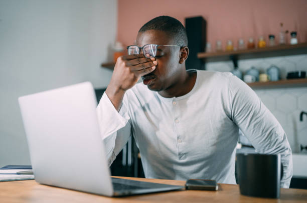 istock Stressed businessman using laptop at home. 1354226842
