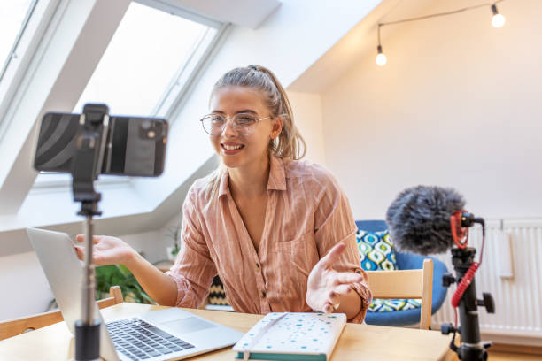 istock Young female vlogger recording video for her video channel. 1354230177