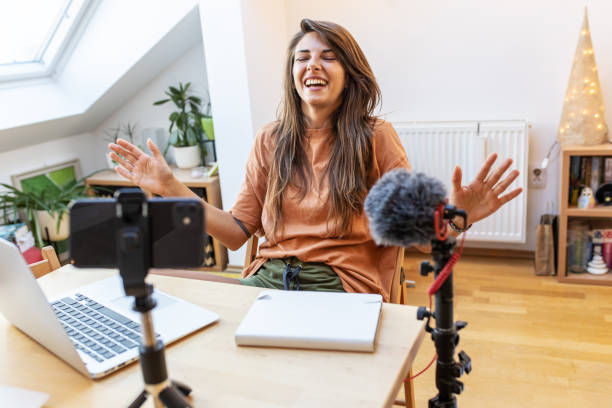 istock Young female vlogger recording video for her video channel. 1354230217