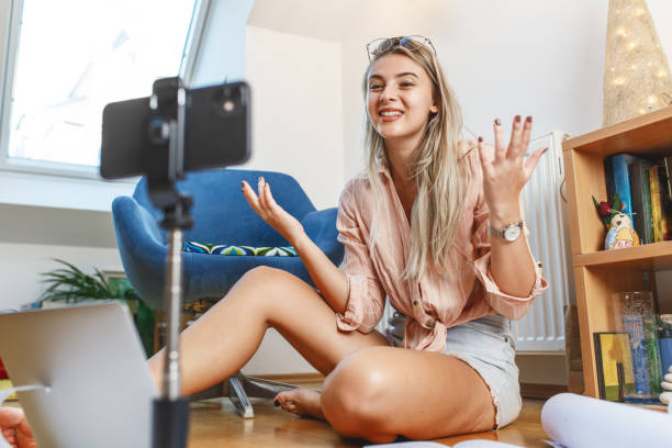 istock Young female vlogger recording video for her video channel. 1354231041