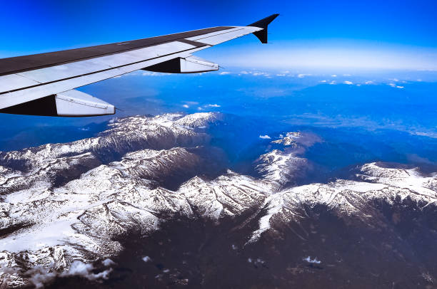 istock Looking through window aircraft during flight in wing with a nice blue sky 1354238190