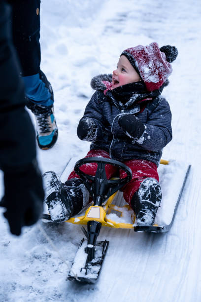 istock Family tobogganing during winter. 1354239686