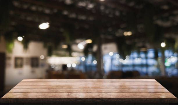 istock Empty wooden table top with lights bokeh on blur restaurant background 1354240164