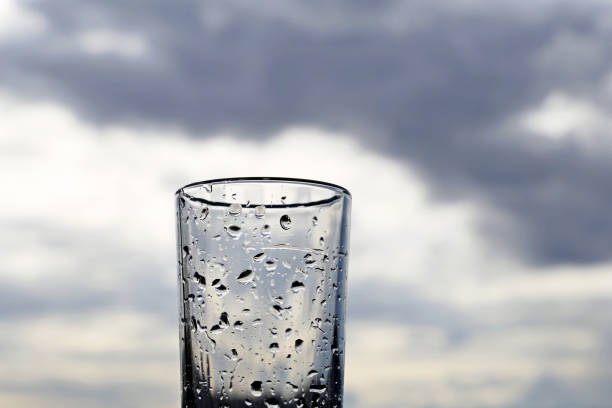 Drinking glass on background of dark sky with storm clouds