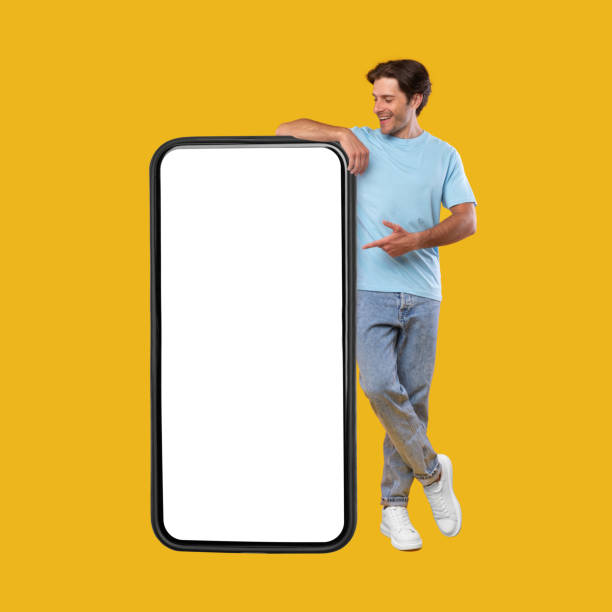 istock Man pointing at big white empty smartphone screen, mock-up 1354241084