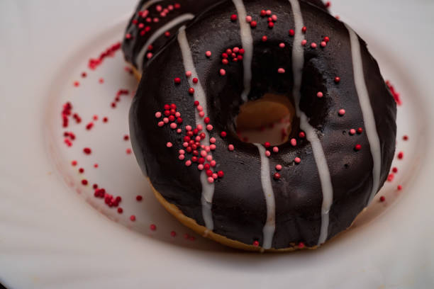 istock donut with chocolate on a white plate with sprinkles 1354241209