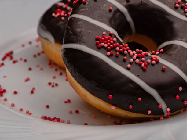 istock donut with chocolate on a white plate with sprinkles 1354241215