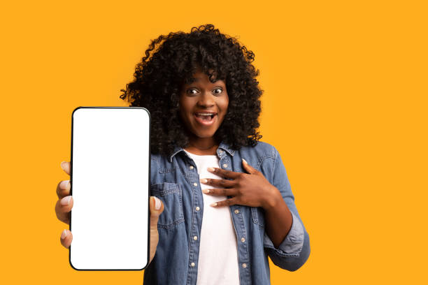 istock Amazed black woman showing big smartphone with blank screen 1354242364