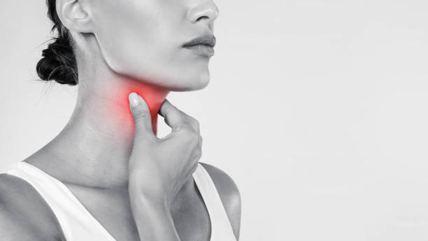 istock Young woman suffering from sore throat, gray studio 1354242434