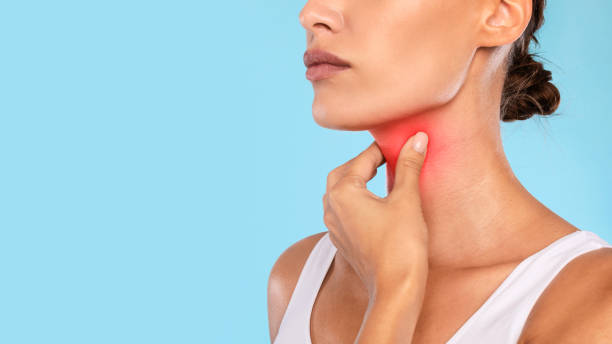 istock Young woman suffering from sore throat, blue studio 1354242787