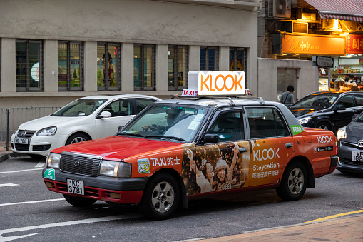 Hong Kong - November 19, 2021 : A taxi with Klook Travel advertisement in Tsuen Wan, New Territories , Hong Kong.