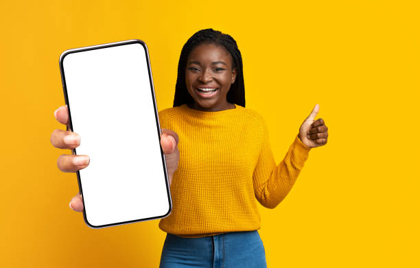 istock Cute pretty black woman showing mobile phone with empty screen 1354243816