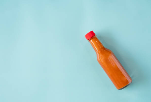 Saturated blue base with one bottle of red hot sauce with lots of copy space.