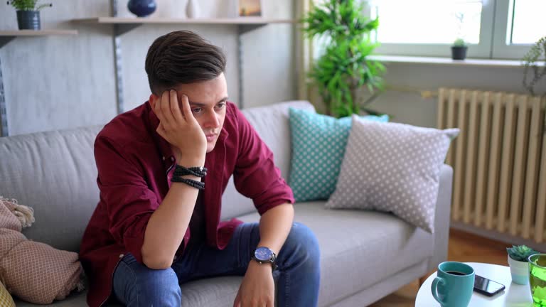 Man sitting alone at home looking sad and distraught