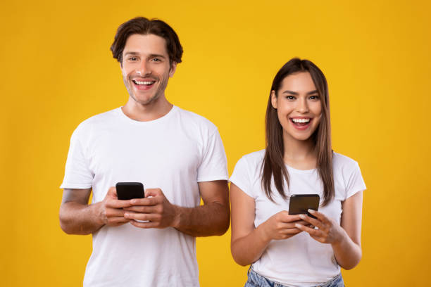 istock Cheerful couple using smartphones standing at studio 1354244077