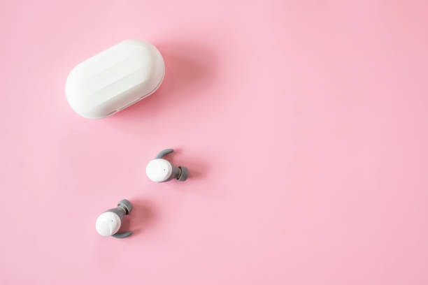 istock Modern earbuds On A Bright Pink Background 1354244124