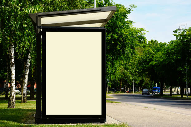 blank white glass commercial ad panel on bus shelter side. city street background. stock photo