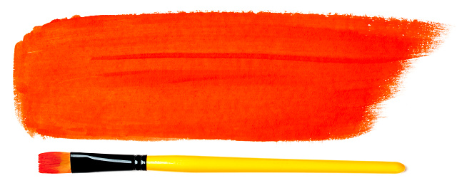 Close-up of a paintbrush with a red paint stroke (gouache). Isolated on a white background. Space for copy.