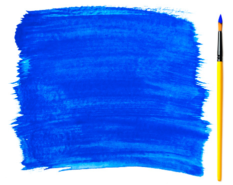 Close-up of a paintbrush with blue paint strokes (gouache). Isolated on a white background. Space for copy.
