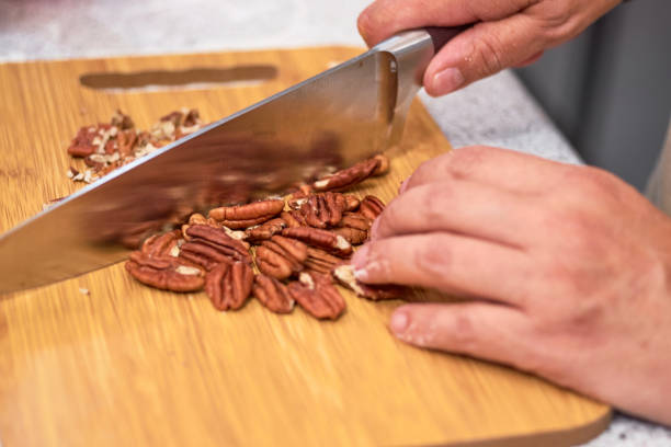 istock Woman cuts walnuts on wooden cutting board. 1354246363