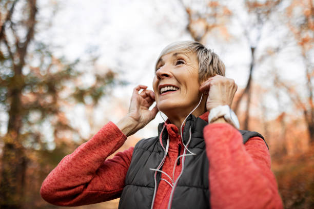 istock Senior woman getting ready for jogging in park against sun 1354247232