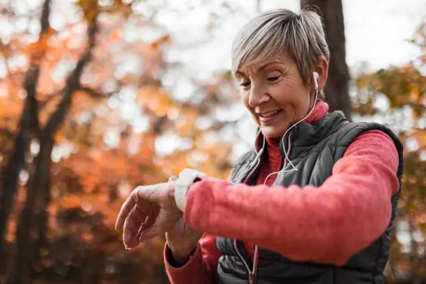 Sporty mature smiling Woman Checking Her Pulse After Exercise