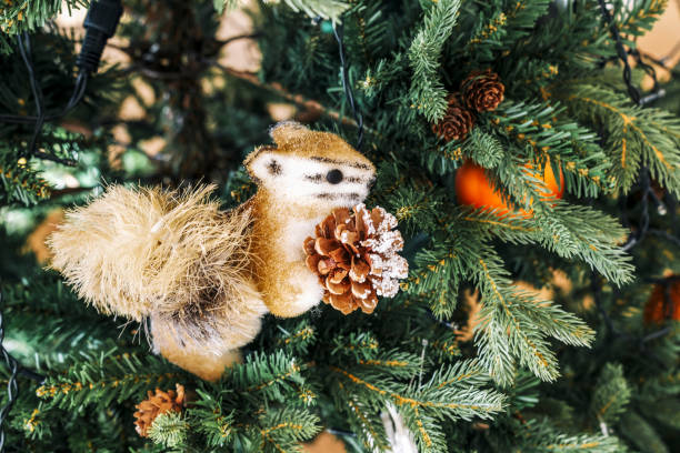 istock Toy Christmas orange Fluffy Squirrel With  Cone  Close-Up Sits on the Christmas tree. 1354248073