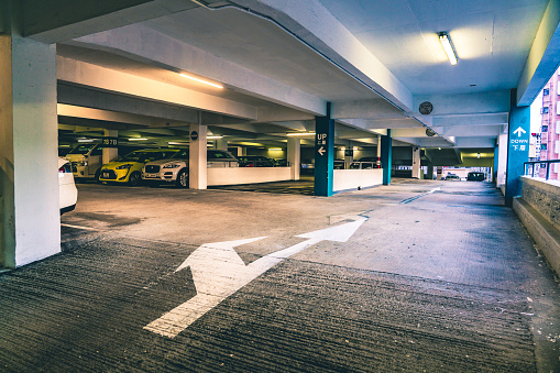 Interior of parking garage with car and vacant parking lot in parking building