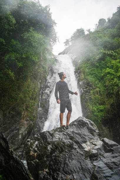 istock young boy standing in front of a waterfall 1354250314