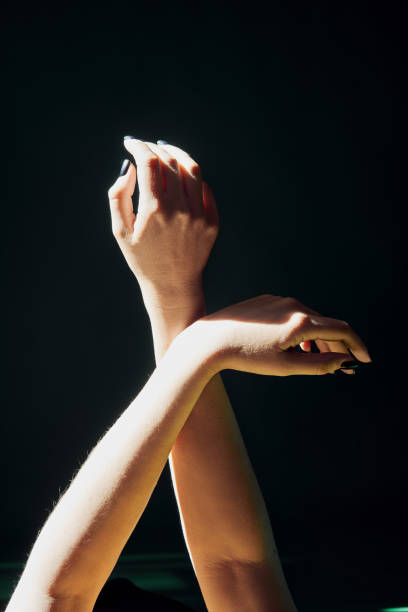istock Beautiful woman's raised hands in ray of sunlight 1354252613