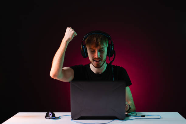 istock Guy gamer winner with headset playing video games on his personal computer 1354252826