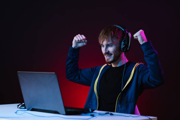 istock Guy gamer winner with headset playing video games on his personal computer 1354252977