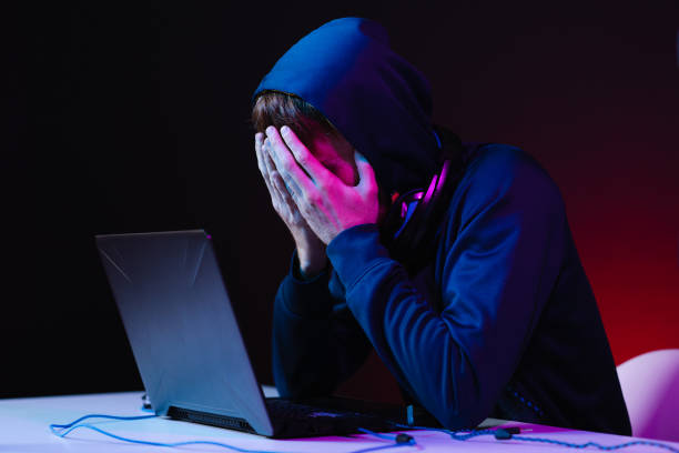 istock Professional hacker with laptop sitting at table on dark background 1354252998