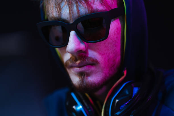 istock Professional hacker with laptop sitting at table on dark background 1354253155