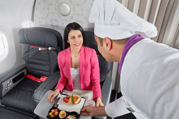 Serving airplane food in first class Chef serving airplane food in first class economy class stock pictures, royalty-free photos & images