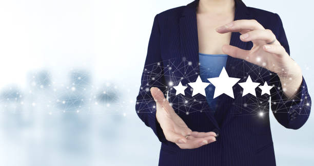 istock Customer Experience Concept. Two hand holding virtual holographic five stars icon with light blurred background. Business satisfaction survey. 1354256371