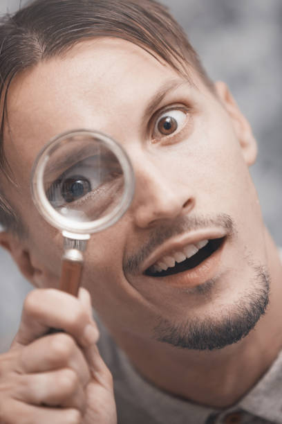 istock Man with magnifying glass. Vertical portrait 1354257728