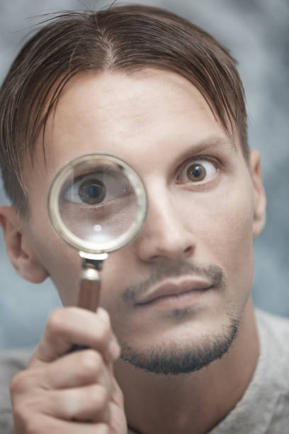 istock Man with magnifying glass. Vertical portrait 1354257742