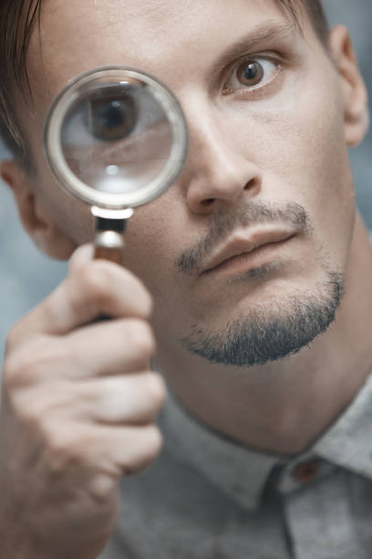 istock Man with magnifying glass. Vertical portrait 1354257750