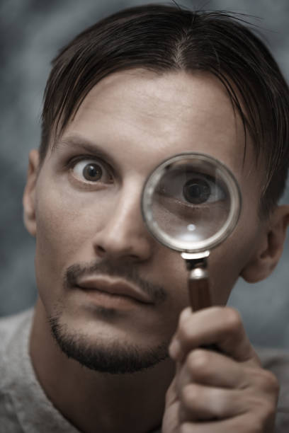 istock Man with magnifying glass. Vertical portrait 1354257751