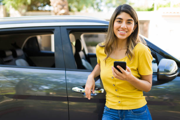 istock Attractive woman texting next to her car 1354258116