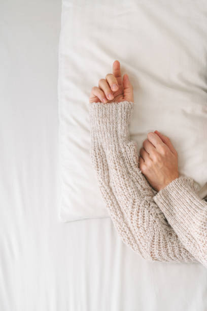 Soft White Pillow with Hand Resting on it in a Cozy Bedroom Setting Inviting Relaxation and Comfort for Sleep and Rest.