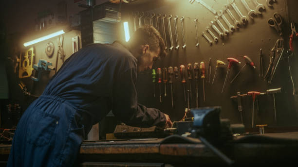istock Young blacksmith checking his tools and supplies to get to work in his workshop, back view 1354259514