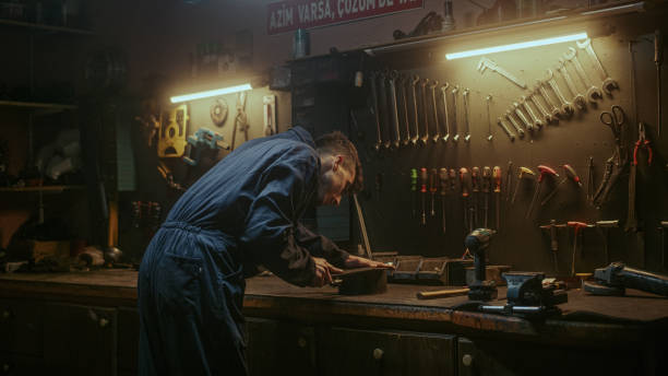 istock Young blacksmith checking his tools and supplies to get to work in his workshop, back view 1354260651
