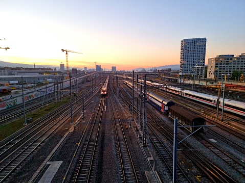 Zurich with a large trackfield of the federal Railways (SBB) and a driving through high speed train. The beautiful image was captured during dusk in autumn season.