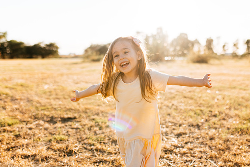 Happy little girl running at sunset. Little girl in nature running and girl in yellow dress