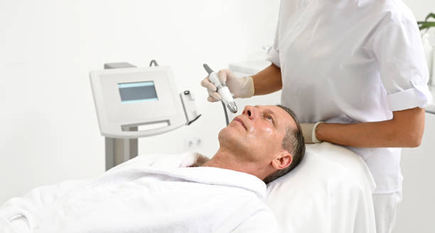Portrait of a middle aged European man receiving professional skin care treatment in wellness spa center. Modern cosmetological medical equipment for anti-aging, revitalizing, rejuvenating treatment retrato de un apuesto hombre europeo maduro que recibe un tratamiento profesional para el cuidado de la piel en un centro de spa de bienestar. moderno equipo médico cosmetológico para el tratamiento antienvejecimiento, revitalizante y rejuvenecedor