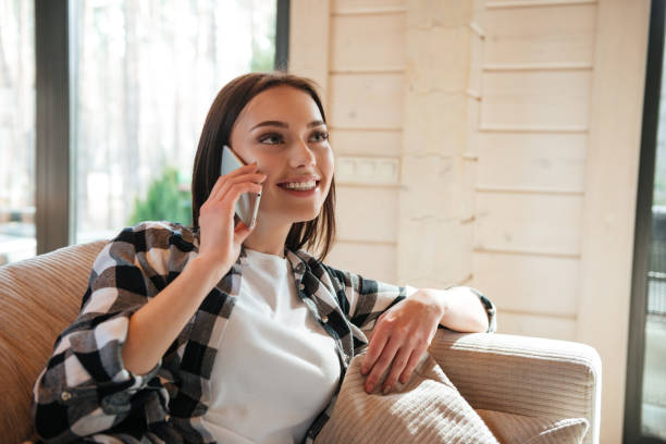 istock Talking on phone in living room 1354267968