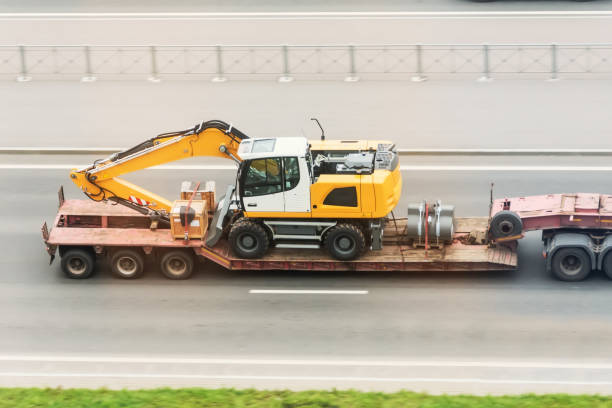 camión remolque con plataforma larga transporta la excavadora en carretera. logística de transporte de carga pesada y sobredimensionada por carretera - pesado fotografías e imágenes de stock